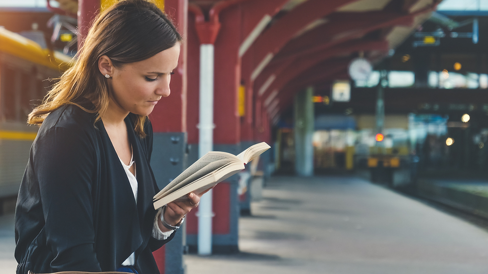lady reading a book while waiting for the train