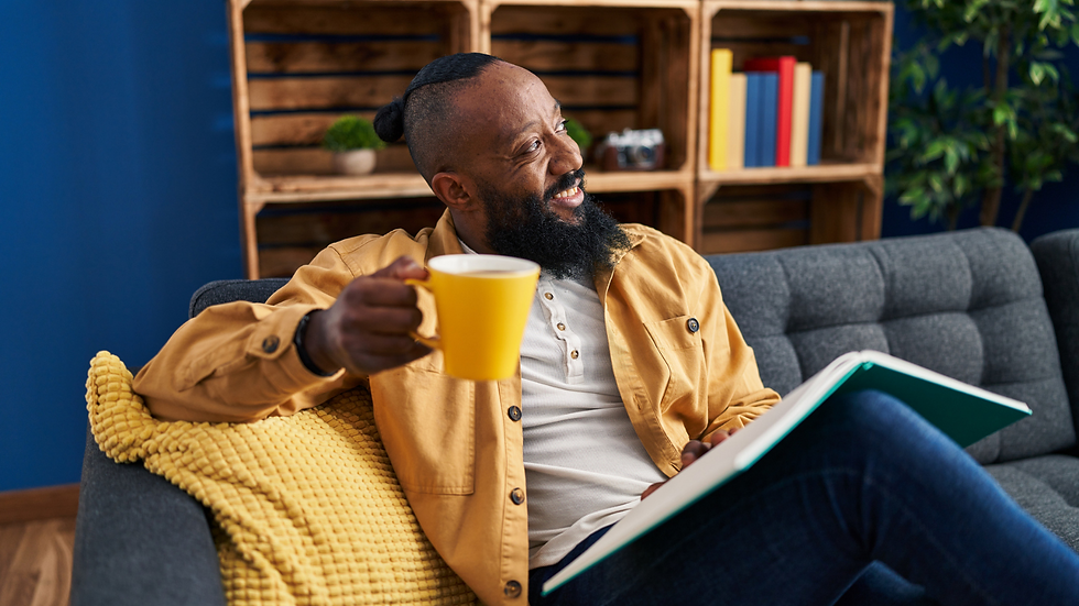man reading a book while drinking coffee